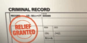 Illustration shows a form that says "CRIMINAL RECORD" at the top, with a red "RELIEF GRANTED" stamp on it.