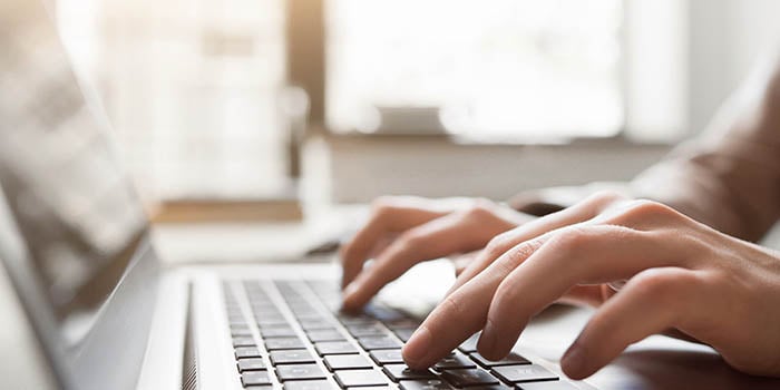 Close up photo of person typing on keyboard.
