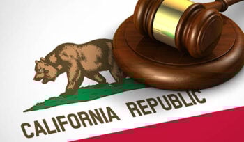 Photo of a judge's gavel on top of the California flag