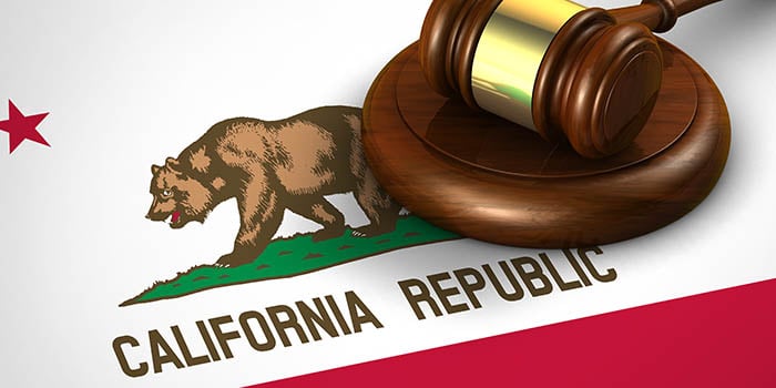 Photo of a judge's gavel on top of the California flag