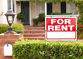 Sign says "FOR RENT" in front of a house