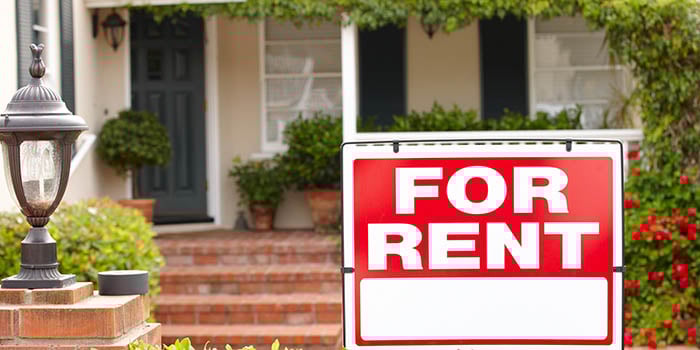 Sign says "FOR RENT" in front of a house