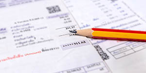 Picture of a monthly bill with a pencil on top.