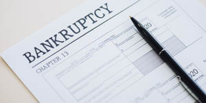 Photo of a form that says "Bankruptcy" and "Chapter 13" with a pen on top of it.