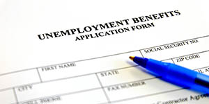 An application form for unemployment insurance with a pen on top of it