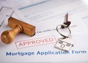 Photo of a mortgage application form marked "APPROVED" along with a set of keys
