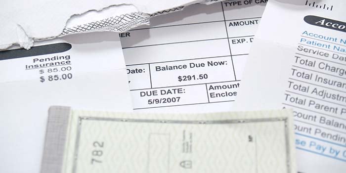 Photo shows a checkbook and medical bills